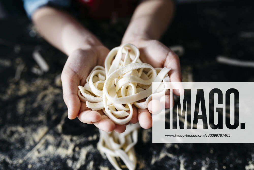 Creative Highlights Symbol Hand holding homemade gluten free pasta in kitchen at home model released Symbolfoto property released JRFF04304