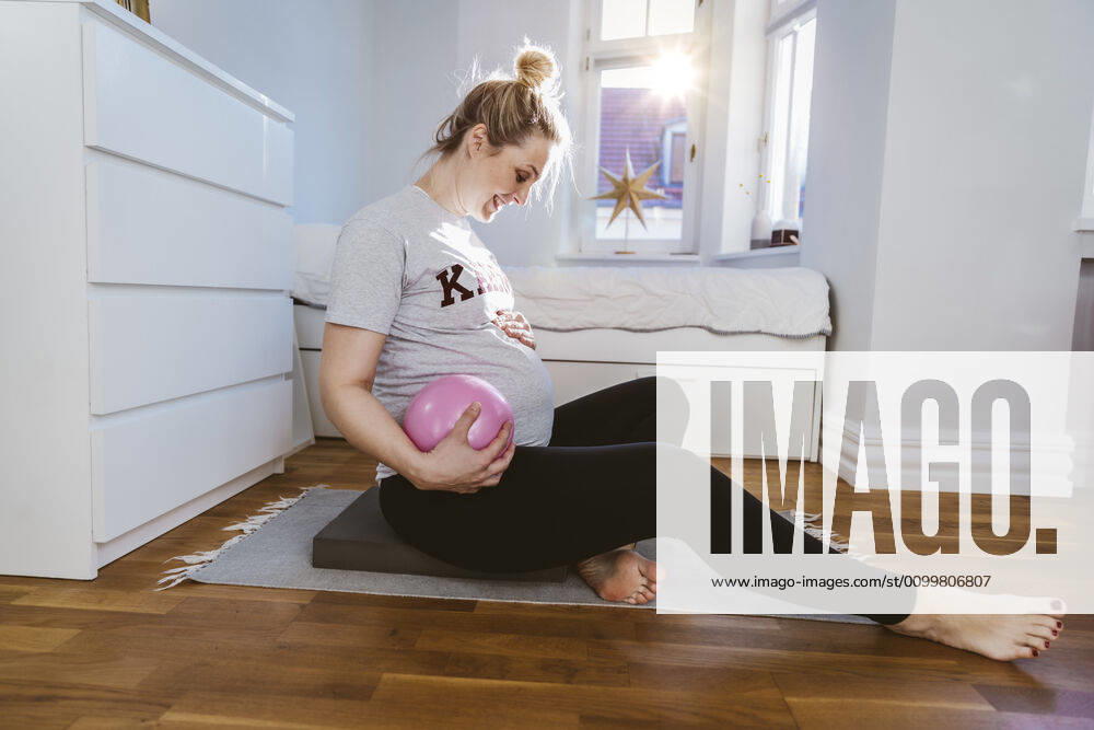 Pregnant woman practising with a ball at home model released Symbolfoto property released MFF05114