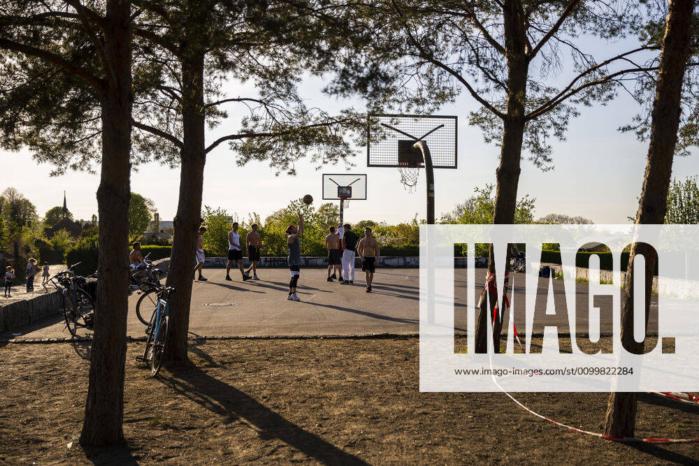 Young men play basketball on a playground in Berlin on 23 April 2020 As of yesterday, under 800 square meters, bookstores and car showrooms can open again with the observance of hygiene and distance regulations Today there were noticeably more people on the road Coronavirus in Berlin