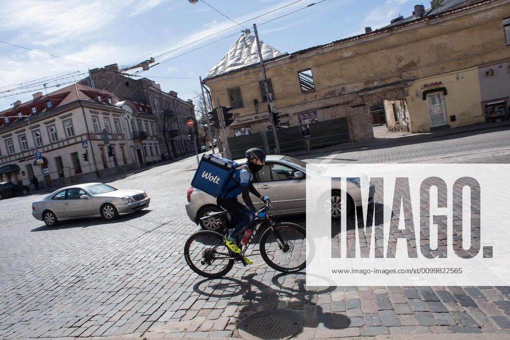 Coronavirus in Litauen, Eindrücke aus Vilnius (200424) -- VILNIUS, April 24, 2020 (Xinhua) -- A deliveryman wearing a mask rides a bicycle in the old town of Vilnius, capital of Lithuania, April 23, 2020. The government of Lithuania on Wednesday extended the nationwide quarantine restrictions until May 11 with the easing measures such as reopening of all shops and shopping malls from Thursday. Th new measures also included letting outdoor cafes, hairdressing, beauty parlors, libraries and museums to resume operation from the start of the next week. (Photo by Alfredas Pliadis Xinhua) LITHUANIA-VILNIUS-COVID-19
