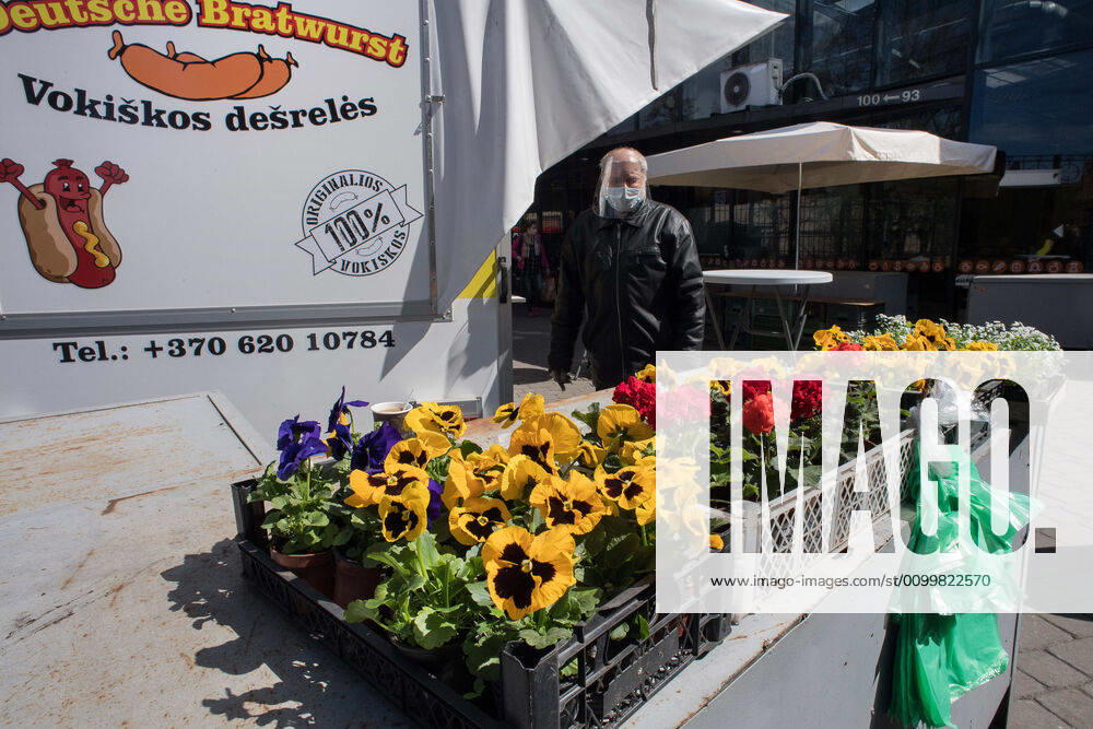 Coronavirus in Litauen, Eindrücke aus Vilnius (200424) -- VILNIUS, April 24, 2020 (Xinhua) -- A man wearing face mask and shield sells flowers in Vilnius, capital of Lithuania, April 23, 2020. The government of Lithuania on Wednesday extended the nationwide quarantine restrictions until May 11 with the easing measures such as reopening of all shops and shopping malls from Thursday. Th new measures also included letting outdoor cafes, hairdressing, beauty parlors, libraries and museums to resume operation from the start of the next week. (Photo by Alfredas Pliadis Xinhua) LITHUANIA-VILNIUS-COVID-19