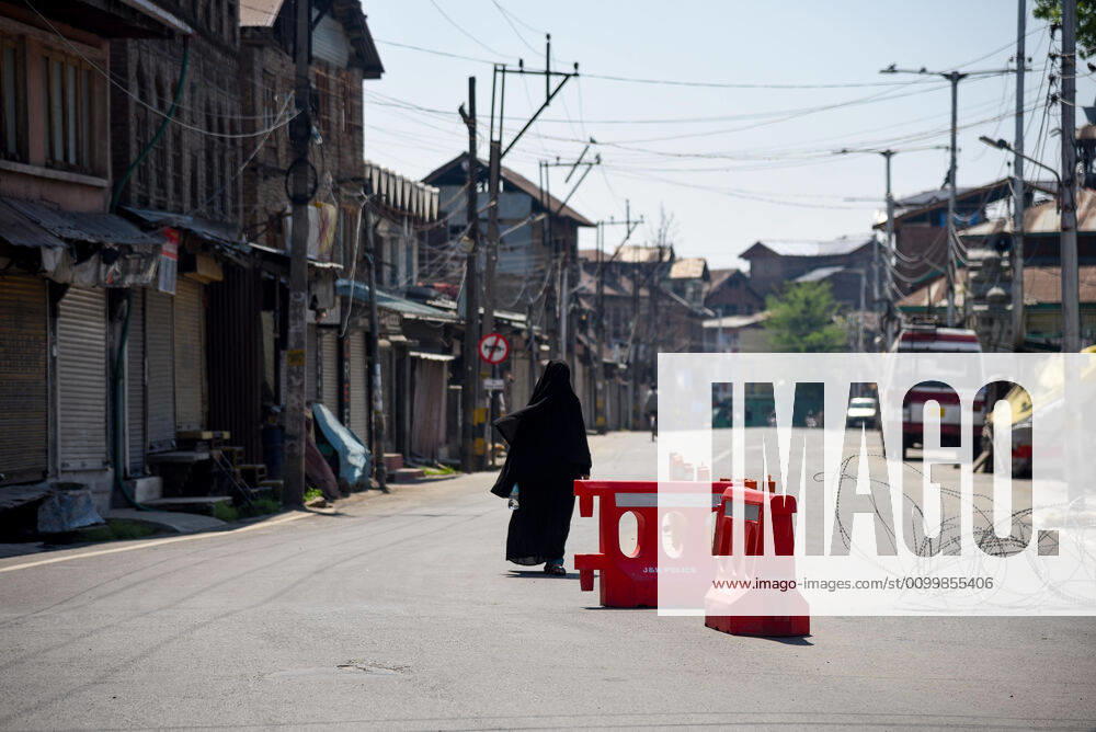 A burqa clad woman walks past barricades set up during the nationwide lockdown..India s Health Ministry has so far recorded a total 23,452 infections, death 272 and recovered 4,814 cases since the beginning of the corona virus outbreak. Srinagar India - ZUMAs197 20200424_zaa_s197_029