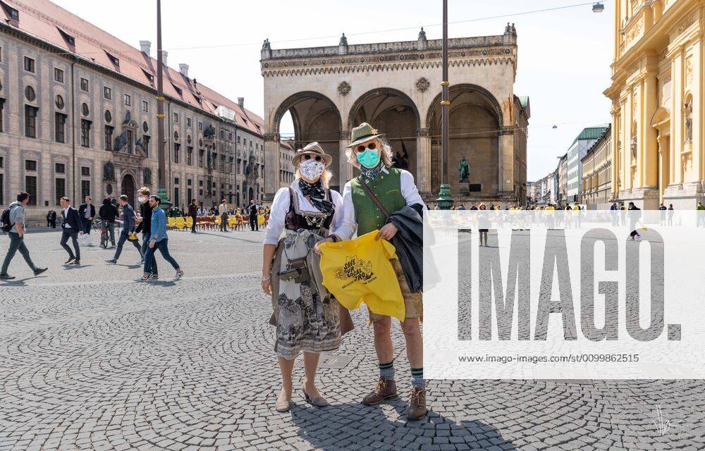 Munich, Odeonsplatz 24. April 2020 Two restaurateurs from Munich demonstrate for the support of the catering industry. They are wearing Bavarian traditional costume and face masks. In the background is the Feldhernhalle Munich - ZUMAv143 20200424_znp_v143_006