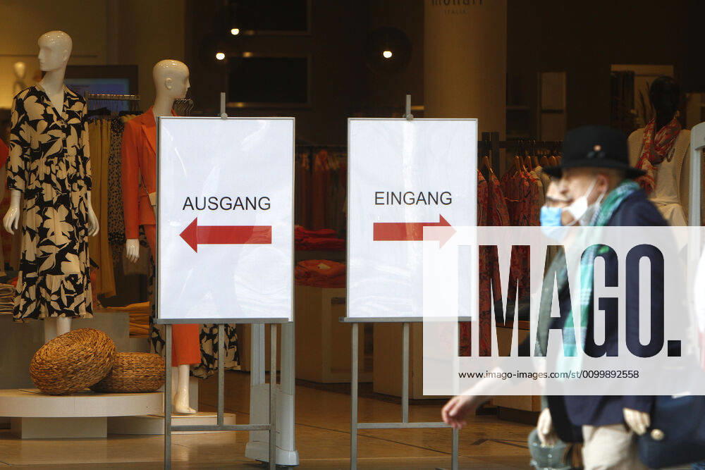Security measures for keeping a distance with separate entrance and exit in front of an open shop in the shopping street and pedestrian zone Zeil in the city centre of Frankfurt, Hesse, Germany