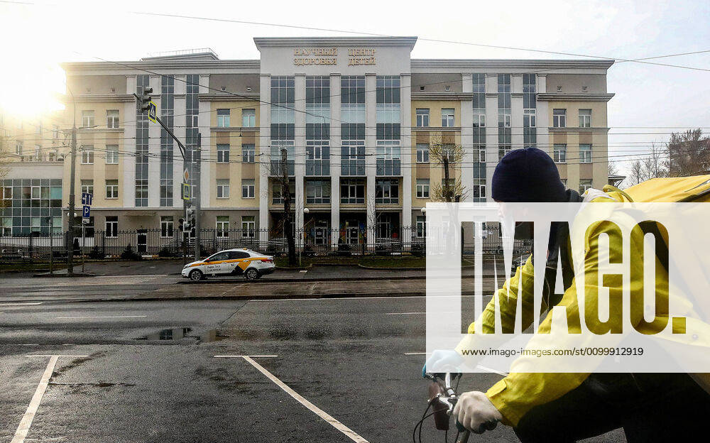 A food delivery worker rides a bicycle past the building of the National Medical Research Centre for Children s Health (NMITS) during the pandemic of the novel coronavirus disease (COVID-19). Part of the research centre has been converted to treat young patients with suspected or confirmed novel coronavirus infection (COVID-19). Valery Sharifulin TASS TS0D7031