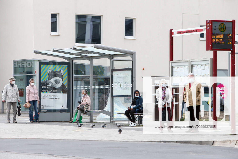 Consequences of the Corona Virus in Wolfsburg, passengers wait for their bus with masks on their faces In Wolfsburg, there is a duty to wear a mask that covers mouth and nose in all shops and on buses Wolfsburg