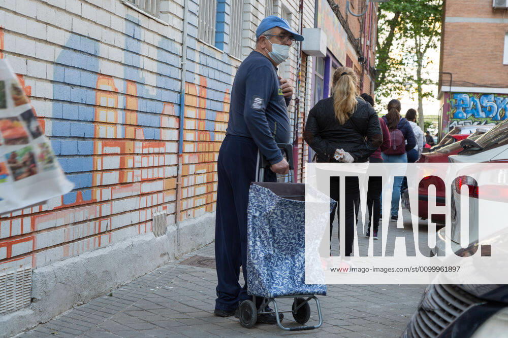Spain: Food distribution due to Covid-19 crisis Several people wait their turn to receive food. Madrid Madrid Spain