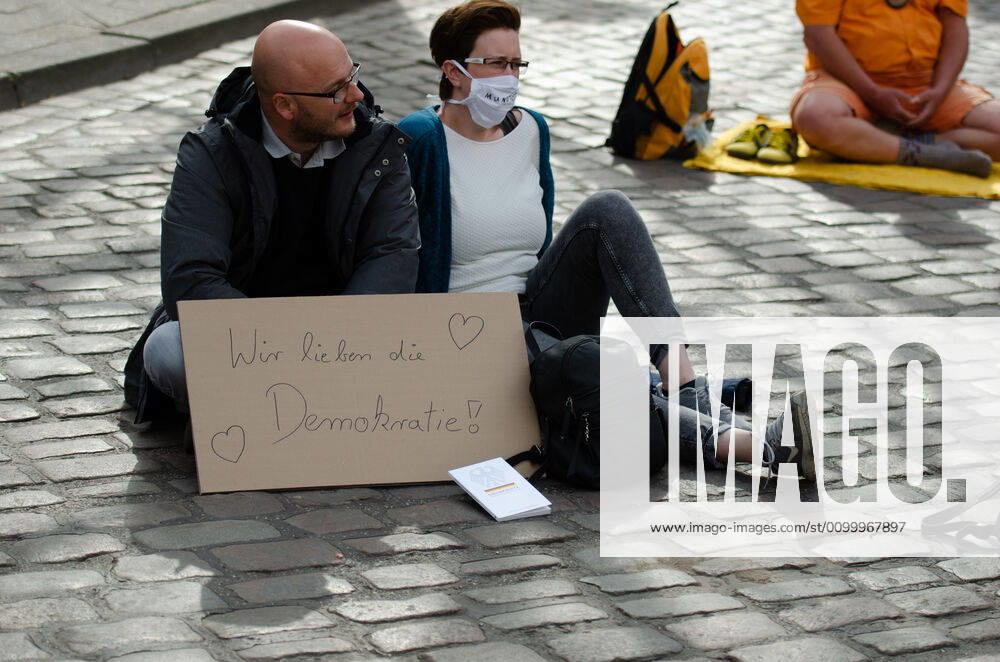 Lockdown immediately end demonstration on Südermarkt in Flensburg The Communication Center Democratic Resistance organizes a demonstration on 25 04 2020 in Flensburg on Südermarkt, downtown Flensburg Two demonstrators sat on the floor, in front of them a banner with the words We love democracy, before that reading the Basic Law