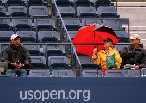 Wahre Tennisfans trotzen dem Regenwetter bei den US Open Tennis Herren US Open 2003, ATP-Tour, Grand Slam, geringes, wenig, leer, Ränge, Tribüne Gruppe Flushing Meadows, Meadow, Schirm New York, schlechtes Wetter, Regenwetter Leere
