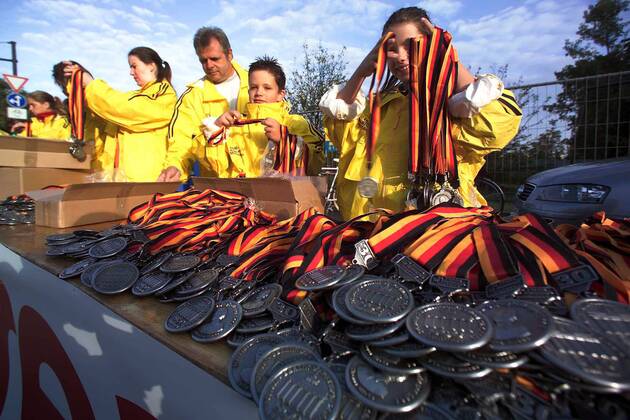 Zwei junge Helfer sortieren die Medaillen, die jeder für die Teilnahme am Berlin-Marathon überreicht bekommt Leichtathletik 30. Internationaler Berlin-Marathon 2003, Stadtmarathon, Citymarathon, Marathonlauf, Langstrecke Totale Berlin