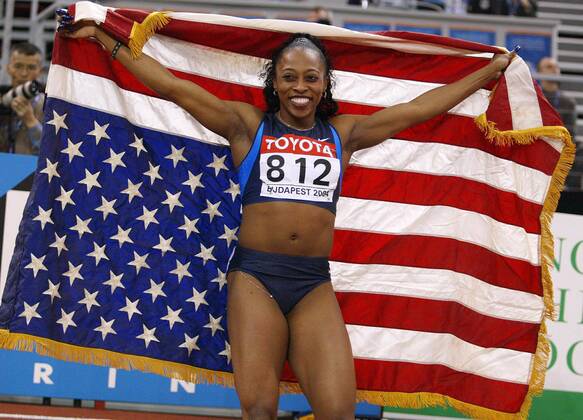 Weltmeisterin Gail Devers (USA) jubelt mit der US-amerikanischen Nationalfahne Leichtathletik WM Damen 10. IAAF Hallen-Weltmeisterschaft 2004, Hallenweltmeisterschaft, Halle, Indoor, Nationaltrikot Einzelbild Budapest Freude,