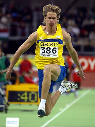 Christian Olsson (Schweden) - Flugphase Leichtathletik WM Herren 10. IAAF Hallen-Weltmeisterschaft 2004, Hallenweltmeisterschaft, Halle, Indoor, Nationaltrikot Einzelbild Budapest Dynamik,