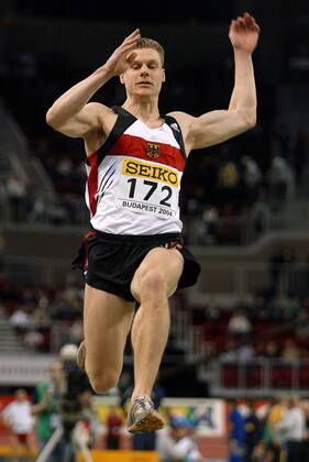Nils Winter (Deutschland) - Flugphase Leichtathletik WM Herren 10. IAAF Hallen-Weltmeisterschaft 2004, Hallenweltmeisterschaft, Halle, Indoor, Nationaltrikot Einzelbild Budapest Dynamik,