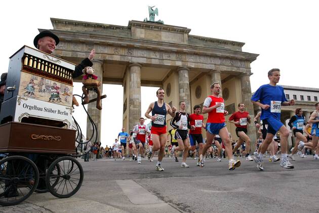 Ein Leierkastenmann begrüßt die Läufer des 24. Berliner Halbmarathons 2004 am Brandenburger Tor Leichtathletik Herren 24. Berliner Halbmarathon 2004, Halb-Marathon, Straßenlauf, Volkslauf, Citymarathon, Vdig Totale Stadtmarathon, Langstrecke Berlin