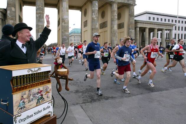 Ein Leierkastenmann begrüßt die Läufer des 24. Berliner Halbmarathons 2004 am Brandenburger Tor Leichtathletik Herren 24. Berliner Halbmarathon 2004, Halb-Marathon, Straßenlauf, Volkslauf, Citymarathon, Vdig Totale Stadtmarathon, Langstrecke Berlin Freude,