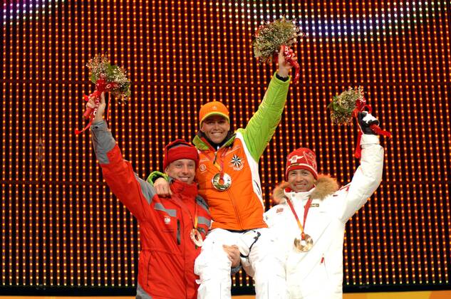 Siegerehrung Massenstart - der Zweitplazierte Tomasz Sikora (Polen, li.) und der Drittplazierten Ole Einar Björndalen (Norwegen) lassen Olympiasieger Michael Greis (Deutschland) hochleben Biathlon OS Winter Herren Olympische Spiele 2006, Winterspiele, Siegerehrung, Podium, Podest, Massenstart, 15km, 15 km Gruppe Medals Plaza, Blumen, Strauß, Blumenstrauß, tragen Turin Freude, Begeisterung,