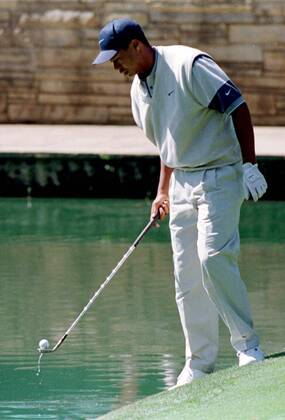 Eldrick Tiger Woods (USA) hat während des Trainings einen Ball im Wasser versenkt und holt ihn mit seinem Schläger wieder heraus -  (AUG97040803) Golf Herren Masters Tournament 1997, PGA Tour, Training Einzelbild Augusta Golf Herren Masters Tournament 1997, PGA Tour, Training Einzelbild Augusta