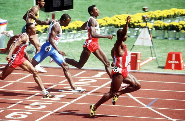BEN JOHNSON (CANADA) RAISES HIS ARM IN TRIUMPH AFTER WINNING THE 100M in front of Carl Lewis and Linford Christie . 1988 OLYMPICS.  o0 Olympiasieg Sieg o0 Leichtathletik