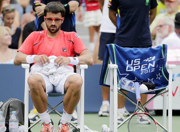 Janko Tipsarevic of Serbia sits during a change over in his match on day 11 in Arthur Ashe Stadium at the BillieJeanKing National Tennis Center in New York City on September 6, 2012. Ferrer defeated Tipsarevic in 5 sets.  NYP20120906128