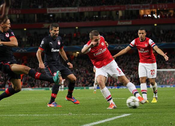 Arsenal s Lukas Podolski scoring his sides second goal..Football - Champions League Matchday 2 - Emirates Stadium, London - 3 10 12EDITORIAL USE ONLY. EDITORIAL USE ONLY. No use with unauthorised audio, video, data, fixture lists, club league logos or live services. Online in-match use limited to 120 images, no video emulation. No use in betting, games or single club league player publications.