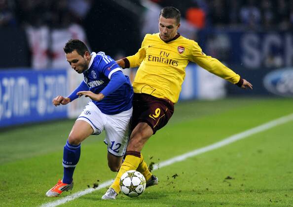 Fussball, UEFA Champions League, Herren, Saison 2012 2013, 4. Spieltag, Gruppe B, Veltins-Arena Gelsenkirchen, FC Schalke 04 (blau) - Arsenal London (gelb) 2:2; Marco Höger, Hoeger (S04), Lukas Podolski (Arsenal), Aktion.