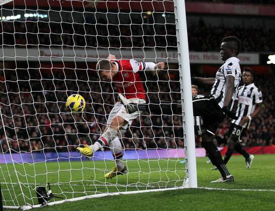 Arsenal s Lukas Podolski scoring his sides third goal..- Arsenal v Newcastle United - Barclays Premier League - the Emirates Stadium, London- 29 12 12 - Picture David Klein Sportimage EDITORIAL USE ONLY. No use with unauthorised audio, video, data, fixture lists, club league logos or live services. Online in-match use limited to 120 images, no video emulation. No use in betting, games or single club league player publications.