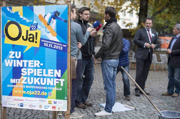 Plakataktion Buergerbegehren pro Olympia 2022, Rindermarkt, München. 22.12.2013 Thomas Muderlak, der Geschäftsführer der BMW Welt, Vorstandssprecher der Tourismus Initiative München, Mitbegründer des Team München 2022 und Sven Hannawald, Skispringer und Rennfahrer kleben Plakate Â
