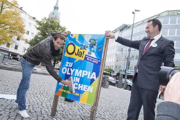 Plakataktion Buergerbegehren pro Olympia 2022, Rindermarkt, München. 22.12.2013 Thomas Muderlak, der Geschäftsführer der BMW Welt, Vorstandssprecher der Tourismus Initiative München, Mitbegründer des Team München 2022 und Sven Hannawald, Skispringer und Rennfahrer kleben Plakate Â
