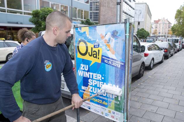 Plakataktion Buergerbegehren pro Olympia 2022, Rindermarkt, München. 22.12.2013 Thomas Muderlak, der Geschäftsführer der BMW Welt, Vorstandssprecher der Tourismus Initiative München, Mitbegründer des Team München 2022 und Sven Hannawald, Skispringer und Rennfahrer kleben Plakate Â