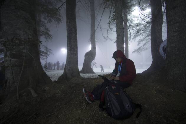(140216) -- SOCHI, Feb. 16, 2014 (Xinhua) -- A reporter works in the fog ahead of Men s Biathlon 15 km Mass Start at the Laura Cross-Country Ski and Biathlon Center during the Sochi Winter Olympics on February 16, 2014. The race was postponed due to heavy fog. (Xinhua Fei Maohua) (SP)OLY-RUSSIA-SOCHI-BIATHLON-MEN S 15KM MASS START-WEATHER 