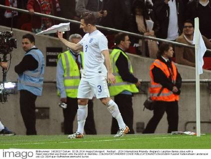 Football - 2014 International Friendly -England s Leighton Baines plays with a Paper plane that was thrown onto the pitch at Wembley. COLORSPORT ANDREW COWIE
