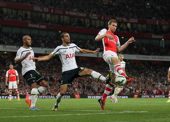Arsenal s Per Mertesacker tussles with Tottenham s Nabil Bentaleb - Barclays Premier League - Arsenal vs Tottenham Hotspur - Emirates Stadium - England - 27th September 2014 - EDITORIAL USE ONLY. No use with unauthorised audio, video, data, fixture lists, club league logos or live services. Online in-match use limited to 120 images, no video emulation. No use in betting, games or single club league player publications.