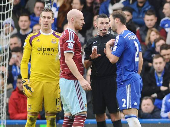 Football - 2014 2015 Premier League - Chelsea vs. West Ham United Chelsea s Branislav Ivanovic is challenged by West ham players, accusing him of diving as Referee Michael Oliver steps in at Stamford Bridge. COLORSPORT ANDREW COWIE