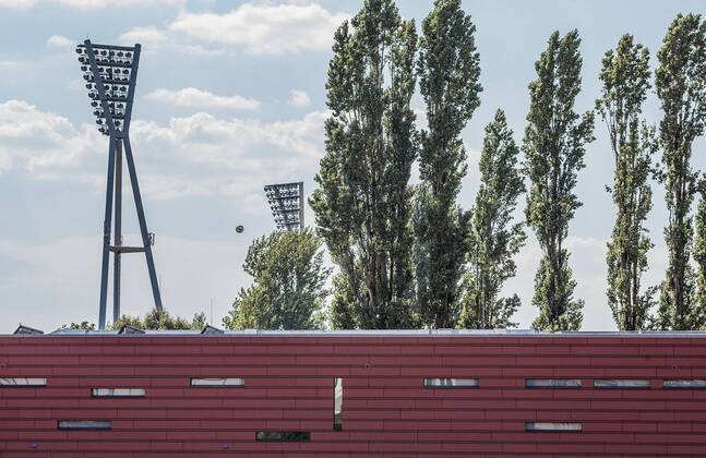 Berlin, Deutschland, 22.08.2015: Fußball Berlin-Liga Saison 2015 2016 - SV Empor Berlin - SD Croatia. Flutlichtmasten vom Friedrich-Ludwig-Jahn-Sportpark, davor die Fassade vom kleinen Stadion