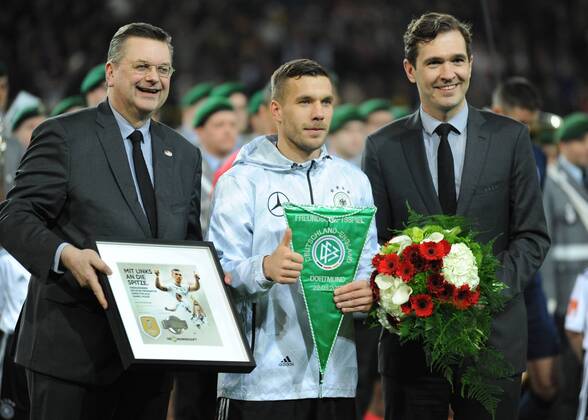 Fußball-Länderspiel: Deutschland - England 22.03.2017 in Dortmund. Lukas Podolski (Deut.) wird vom DFB geehrt. Li: DFB-Präsident Reinhard Grindel. Re: DFB-Generalsekretär Dr. Friedrich Curtius. HM