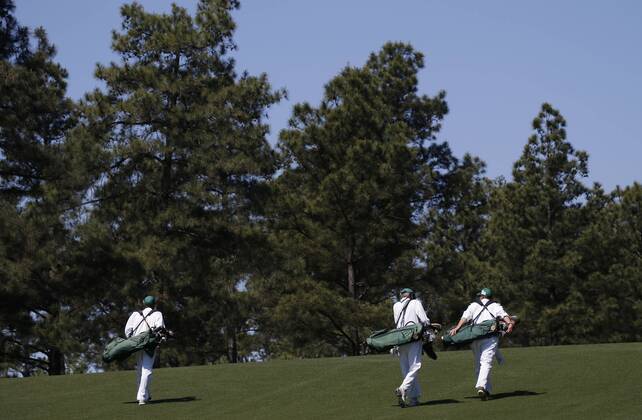Three caddies walk up the first hole fairway at a practice round at the 2017 Masters Tournament at Augusta National Golf Club in Augusta, Georgia on April 2, 2017.  AUG20170402113 JOHNxANGELILLO