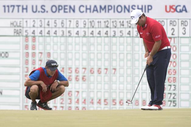 Patrick Reed and his caddie Kessler Karain line up a putt on the 18th green during round 3 of the 117th U.S. Open golf tournament at Erin Hill golf course on June 17, 2017 in Erin, Wisconsin.  WIS20170617305 KEVINxDIETSCH