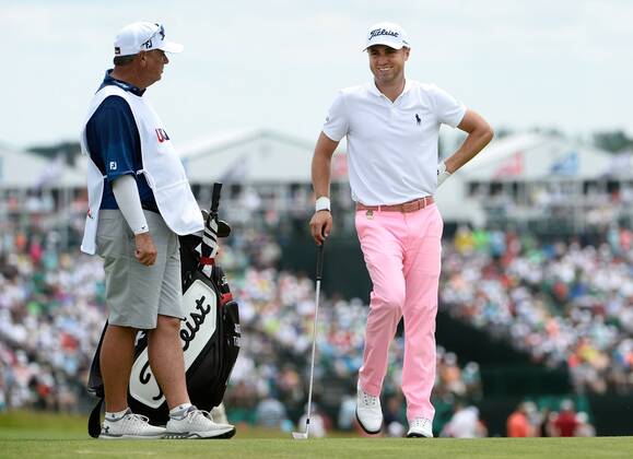 Justin Thomas (R) talks with his caddie as he waits for the group ahead on the 10th fairway during round 3 of the 117th U.S. Open golf tournament at Erin Hill golf course on June 17, 2017 in Erin, Wisconsin.  WIS20170617104 BRIANxKERSEY