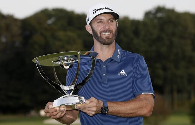 Dustin Johnson holds the championship trophy on the 18th green after he makes a birdie on the first playoff hole in his playoff against Jordan Spieth in the final round of The Northern Trust golf championship at the Glen Oaks Club in Old Westbury, New York on August 27, 2017. Johnson wins The Northern Trust with a score of 13 under par.  NYP20170827119 JOHNxANGELILLO