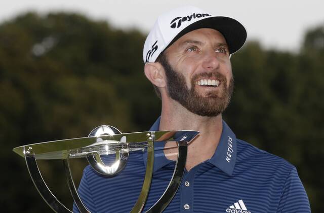 Dustin Johnson holds the championship trophy on the 18th green after he makes a birdie on the first playoff hole in his playoff against Jordan Spieth in the final round of The Northern Trust golf championship at the Glen Oaks Club in Old Westbury, New York on August 27, 2017. Johnson wins The Northern Trust with a score of 13 under par.  NYP20170827120 JOHNxANGELILLO