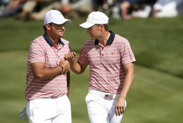 Patrick Reed, left, and Jordan Spieth of United States fist bump after completing play on the ninth hole on day two of the Presidents Cup on September 29, 2017 at Liberty National Golf Club in Jersey City, New Jersey.  NYP20170929517 RICHxSCHULTZ