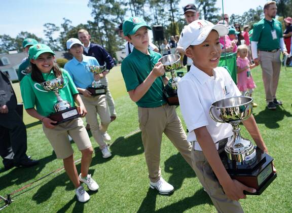 Winners in the Drive Chip & Putt National Finals carry their trophies at Augusta National Golf Club during Masters week on April 1, 2018 in Augusta, Georgia.  AUG20180401323 KEVINxDIETSCH