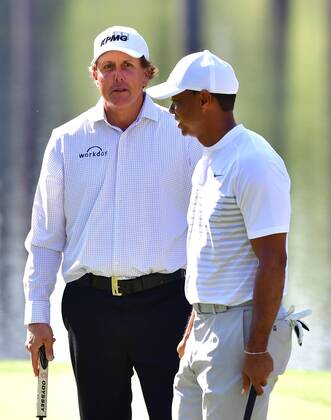 While Mickelson (L) and Tiger Woods talk as they prepare to putt no the 16th green during a practice round prior to the Masters golf tournament at the Augusta National Golf Club, on April 3, 2018 in Augusta, Georgia.  AUG20180403308 KEVINxDIETSCH