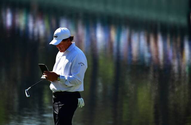 Phil Mickelson looks at notes on the 16th green during a practice round prior to the Masters golf tournament at the Augusta National Golf Club, on April 3, 2018 in Augusta, Georgia.  AUG20180403322 KEVINxDIETSCH