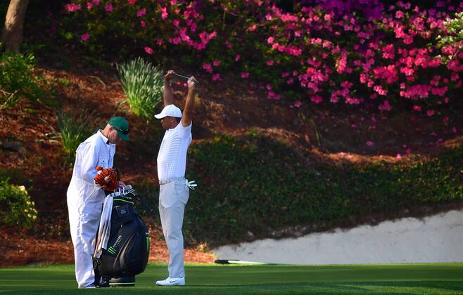 Tiger Woods stretches on the 12th green during a practice round prior to the Masters golf tournament at the Augusta National Golf Club, on April 3, 2018 in Augusta, Georgia.  AUG20180403327 KEVINxDIETSCH