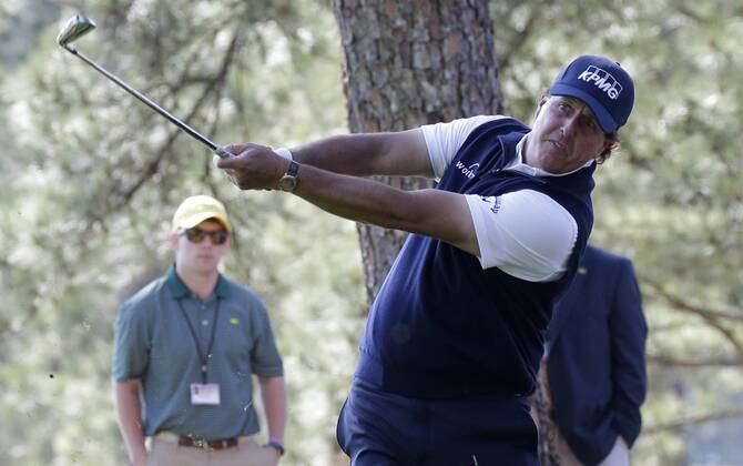 Phil Mickelson hits his second shot from out of the pine straw to the 1st hole in the 2nd round of the 2018 Masters Tournament at the Augusta National Golf Club in Augusta, Georgia, on April 6, 2018.  AUG20180406106 JOHNxANGELILLO