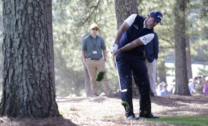Phil Mickelson hits his second shot from out of the pine straw to the 1st hole in the 2nd round of the 2018 Masters Tournament at the Augusta National Golf Club in Augusta, Georgia, on April 6, 2018.  AUG20180406107 JOHNxANGELILLO