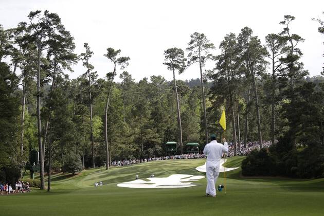 A caddie watches play on the 10th green in the 2nd round of the 2018 Masters Tournament at the Augusta National Golf Club in Augusta, Georgia, on April 6, 2018.  AUG20180406152 JOHNxANGELILLO