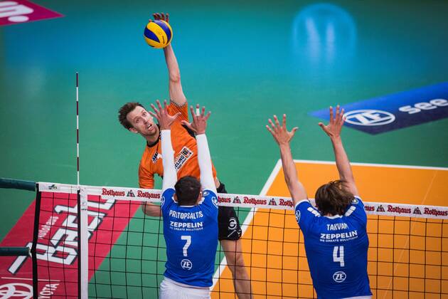 Friedrichshafen Germany 26 04 2018 Paul Carroll BR Volleys 12 against the block from Athanasios Protopsaltis Friedrichshafen 7 and Andreas Takvam Friedrichshafen 4 at the Playoff Final Game 1 of the Volleyball Bundesliga between VfB Friedrichshafen and the Berlin Recycling Volleys
