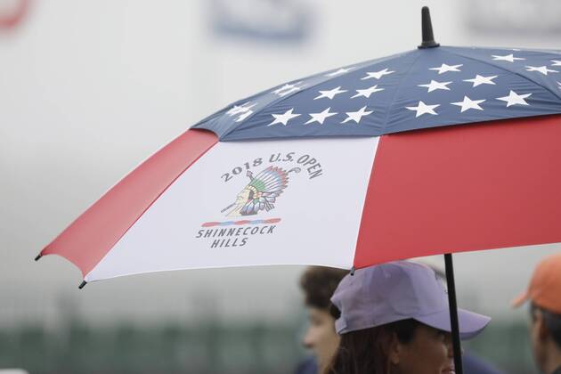 Fans stand under an umbrella on the Wednesday before the 118th U.S. Open Championship at Shinnecock Hills Golf Club in Southampton, New York on June 13, 2018.  NYP20180613301 JOHNxANGELILLO